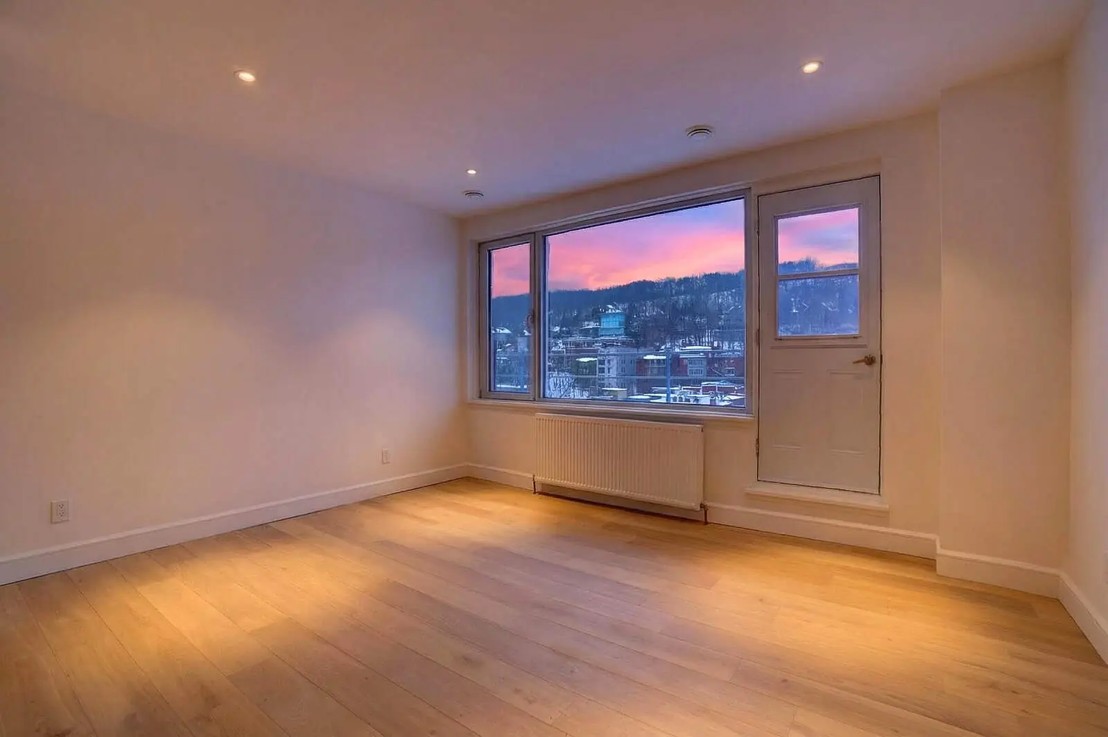 Séjour d'un penthouse au crépuscule avec vue sur le mont Royal